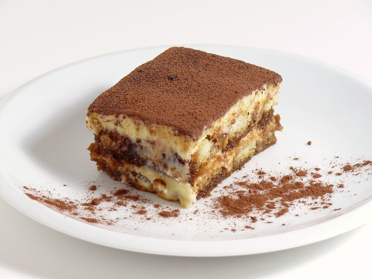 Porción de tiramisú espolvoreada con cacao